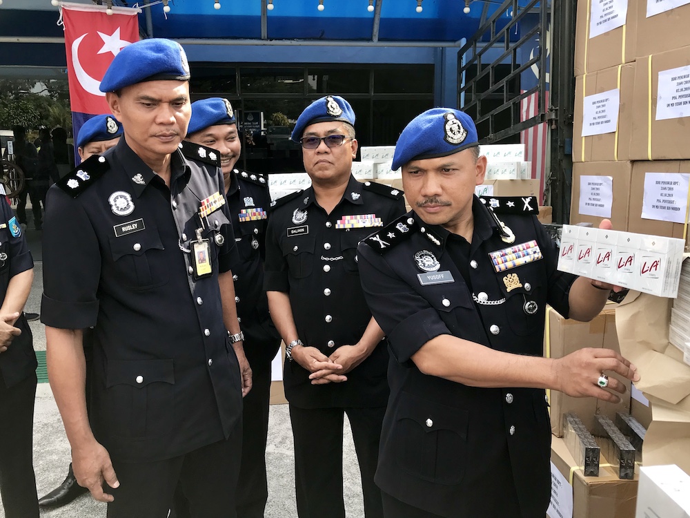 Marine police force commander Senior Assistant Commissioner Mohd Yusoff Mamat (far right) with part of the seized contraband cigarettes in Tampoi, Johor Baru October 4, 2018. u00e2u20acu201d Picture by Ben Tan