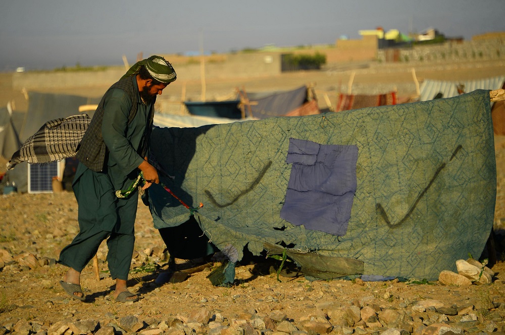 In this photo taken on August 5, 2018, a drought-displaced Afghan man erects a tent at a camp for internally displaced people in Injil district of Herat province. u00e2u20acu201d AFP pic      