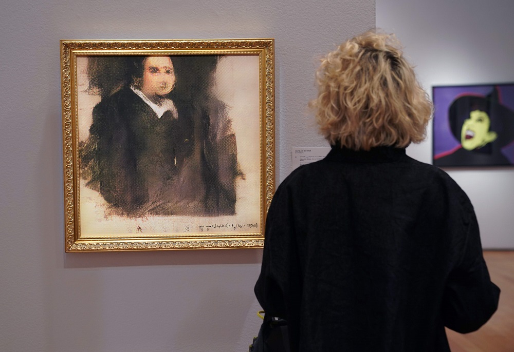 A woman looks at a work of art created by an algorithm by French collective named OBVIOUS which produces art using artificial intelligence, titled u00e2u20acu02dcPortrait of Edmond de Belamyu00e2u20acu2122 at Christieu00e2u20acu2122s in New York on October 22, 2018. u00e2u20acu201d AFP pic
