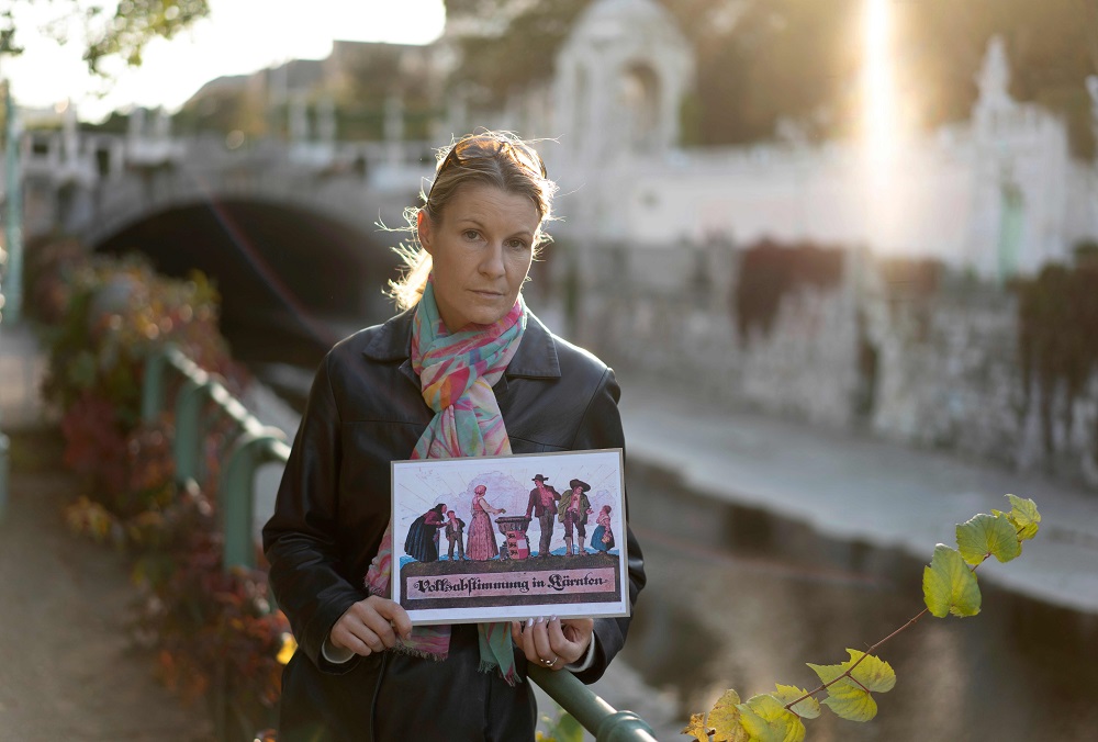 Carmen Kuster, poses with an image showing a family in traditional costume casting its vote into a ballot box emblazoned with Carinthiau00e2u20acu2122s coat of arms, in Vienna, Austria October 5, 2018. u00e2u20acu201d AFP pic