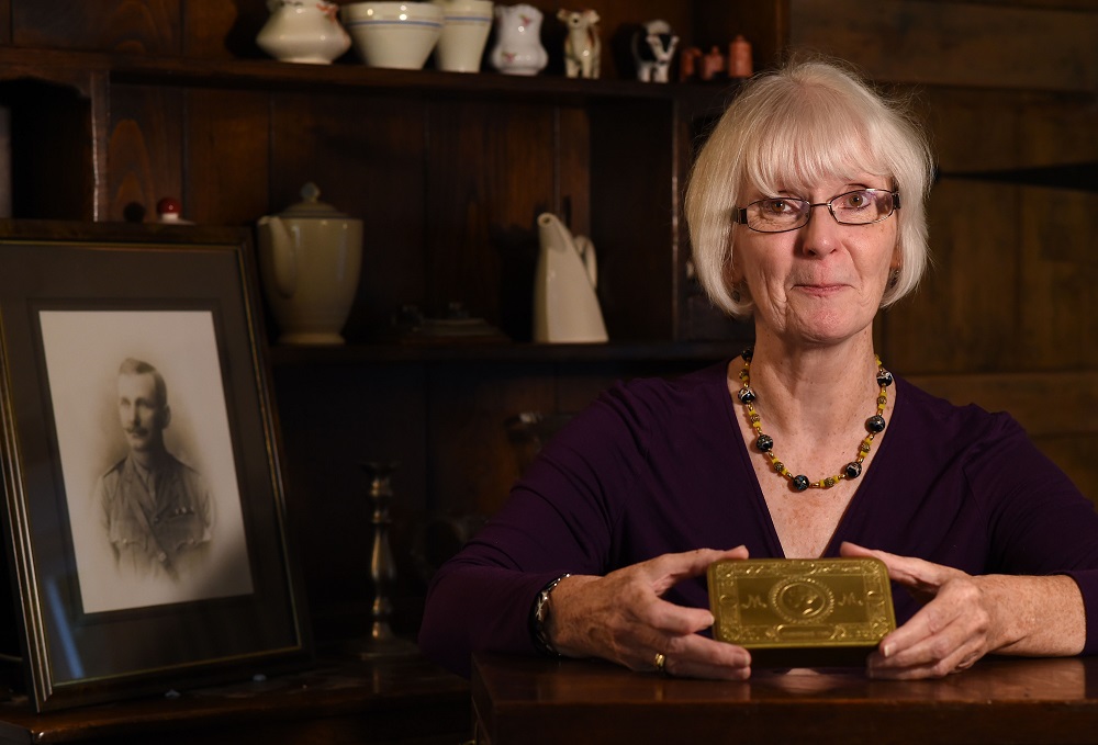 Melanie Henwood poses with the tin box given to her great-grandfather Enoch Davis who fought in World War One with a portrait of Davis in the background at her home in Hartwell, England October 10, 2018. u00e2u20acu201d AFP pic 