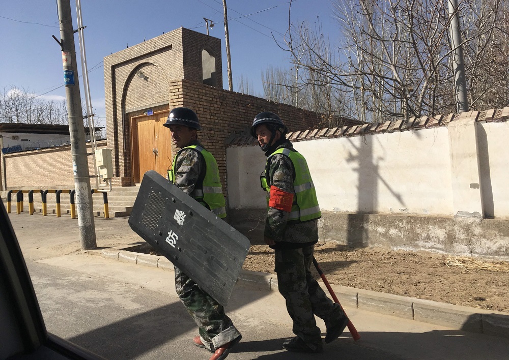 This photo taken on February 17, 2018, shows local police patrolling a village in Hotan prefecture, in Chinau00e2u20acu2122s western Xinjiang region. u00e2u20acu201d AFP pic 