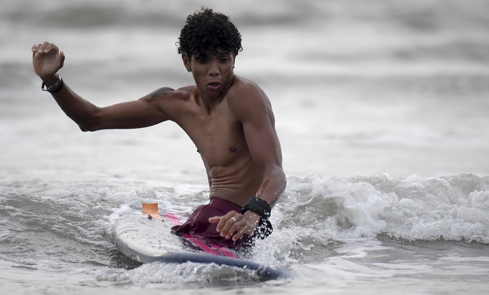 Venezuelan migrant and rap singer Alfonso Mendoza aka u00e2u20acu02dcAlcau00e2u20acu2122, 25, enjoys surfing in Puerto Colombia, outside of Barranquilla, Colombia September 27, 2018. u00e2u20acu201d AFP pic
