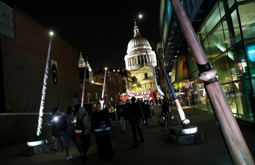 Visitors to the ‘Fantastic Beasts: The Crimes of Grindelwald’ light installation walk among tall versions of the nine wands of the Wizarding World universe, in London October 18, 2018. — Reuters pic