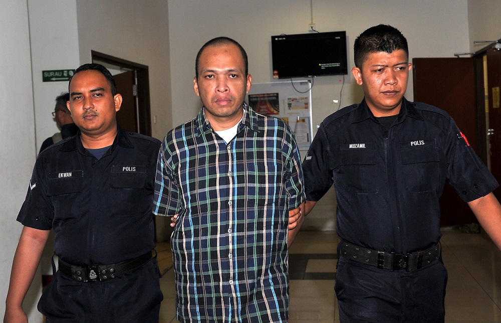 Mohd Azmirul (centre) is escorted out of the Shah Alam High Court October 15, 2018. u00e2u20acu201d Bernama pic