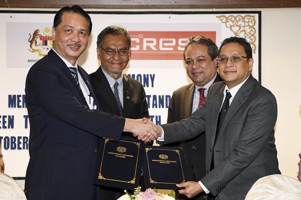 Minister of Health Dzulkefly Ahmad (second left) together with MIDA CEO Datuk Azman Mahmud (second right) witnessed the exchange of documents during the MoU between The Ministry of Health and CREST in Petaling Jaya October 4, 2018. u00e2u20acu201d Bernama