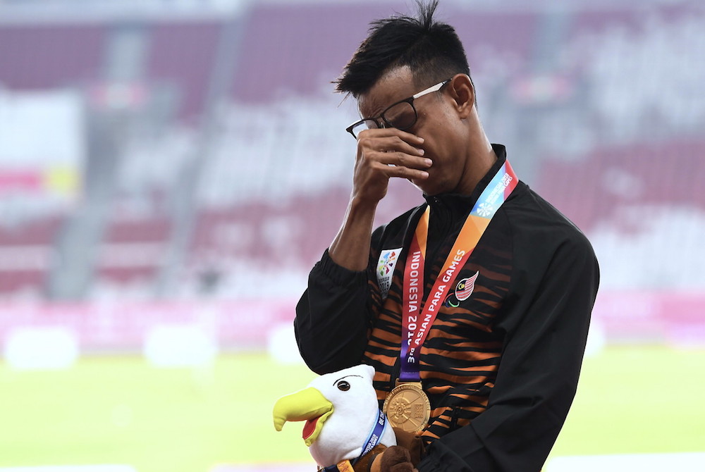 Malaysian para athlete Mohamad Ridzuan Puzi is overcome with emotion after setting a new world record in the menu00e2u20acu2122s 100m T36 (cerebral palsy) at the Asian Para Games 2018 in Jakarta October 9, 2018. u00e2u20acu201d Bernama pic