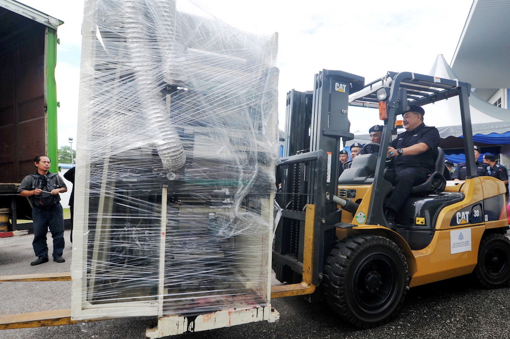 Penang Deputy Police chief Datuk Roslee Chik drives a forklift loaded with confiscated drug-processing machines at the central store of the Penang Police Contingent in Kepala Batas October 16, 2018. u00e2u20acu201d Bernama pic