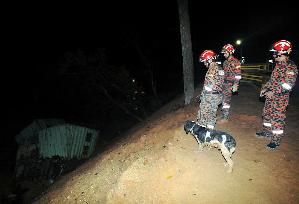 Fire and Rescue Department personnel search for victims of the landslide at Paya Terubong in George Town October 19, 2018. u00e2u20acu201d Bernama pic