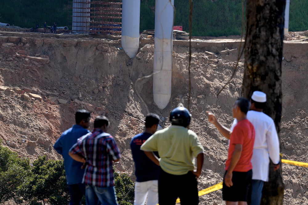 People gather at the site of the landslide at Paya Terubong in George Town October 21, 2018. u00e2u20acu201d Bernama pic