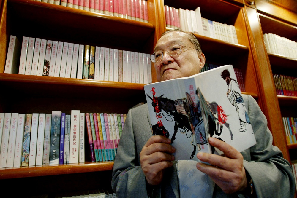 Novelist Louis Cha, who writes under the name Jin Yong, holds his book u00e2u20acu02dcBook and Sword, Gratitude and Revengeu00e2u20acu2122 at his office in Hong Kong July 29, 2002. u00e2u20acu201d Reuters pic