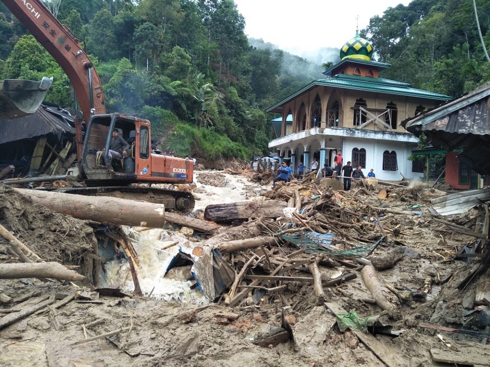 People use a heavy equipment to remove debris after flash floods hit the Saladi village in Mandailing Natal, North Sumatra October 13, 2018. u00e2u20acu201d AFP pic