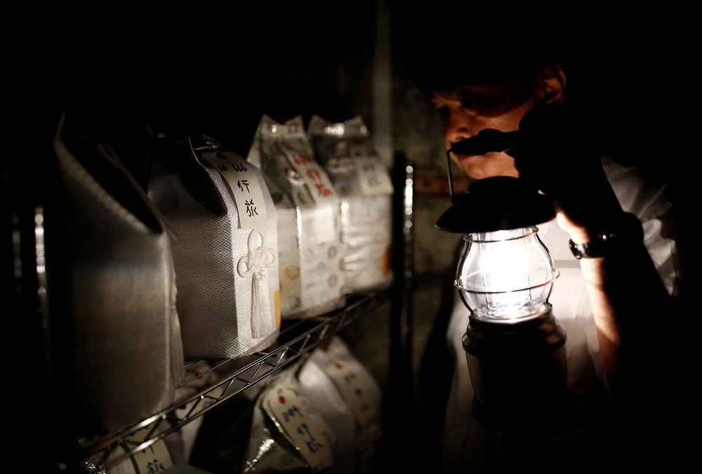 Kazuyuki Kitami, a city official of Yokosuka, holds a lantern as he visits a facility which keeps the unclaimed burial urns containing ashes of the dead in Yokosuka, Japan September 11, 2018. u00e2u20acu201d Reuters pic  