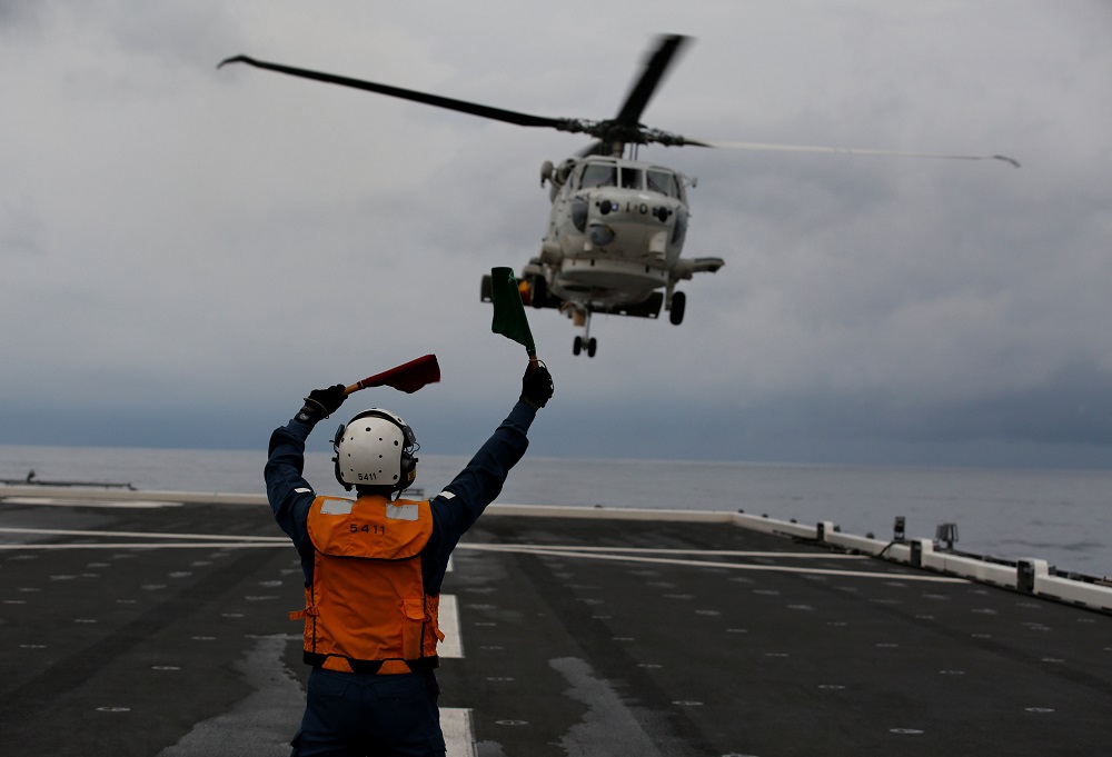 Akiko Ihara, a female flight deck crew of Japanese helicopter carrier Kaga, guides for the landing of a SH-60K Sea Hawk helicopter on the flight deck in the Indian Ocean, Indonesia September 24, 2018. u00e2u20acu201d Reuters pic