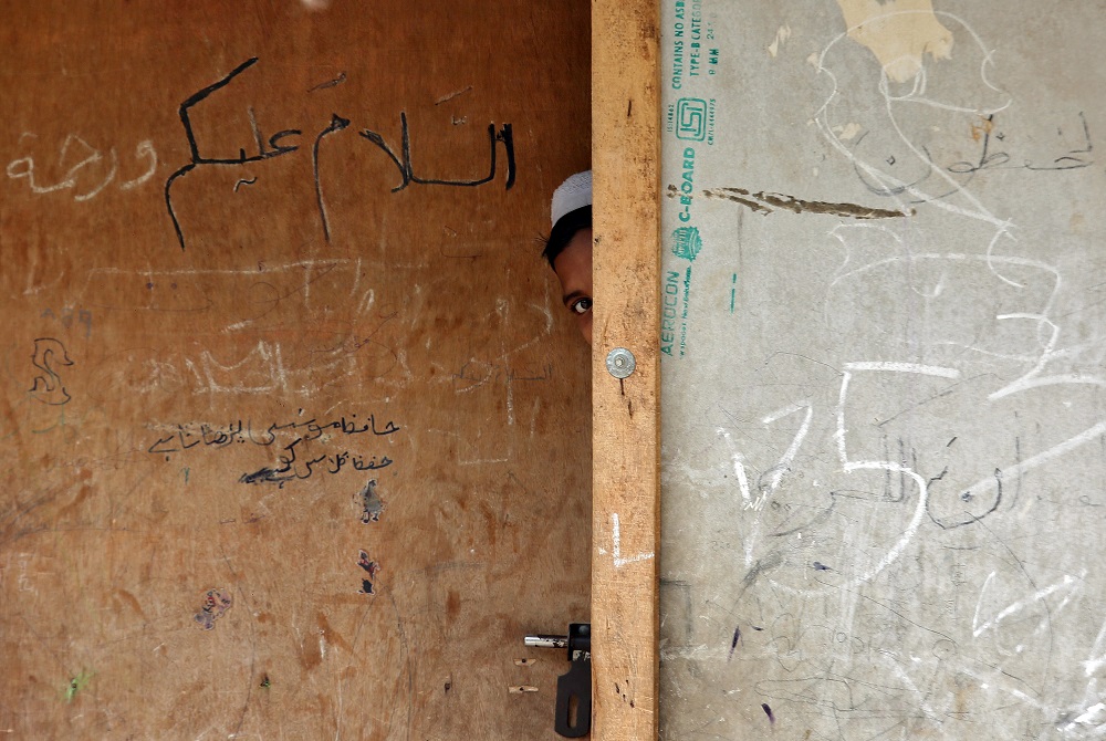 A boy from the Rohingya community peeps out from the door of a madrasah, or a religious school, at a camp on the outskirts of Jammu October 5, 2018. u00e2u20acu201d Reuters pic