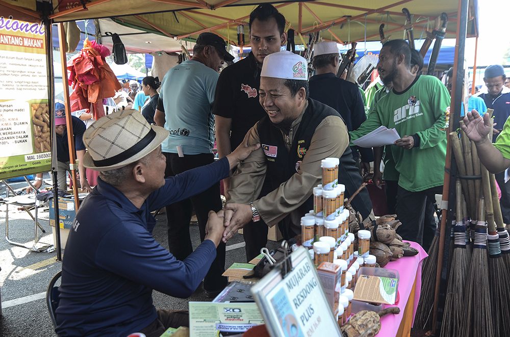 PAS candidate Lt Col (Rtd) Mohd Nazari Mokhtar conducts a campaign walkabout at the Batu 4 Wet Market in Port Dickson October 3, 2018. — Picture by Miera Zulyana