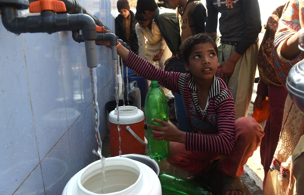 In this picture taken on February 26, 2018, shows Pakistani residents filling their pots with drinking water from a handpump on the outskirts of Lahore. u00e2u20acu201d AFP pic