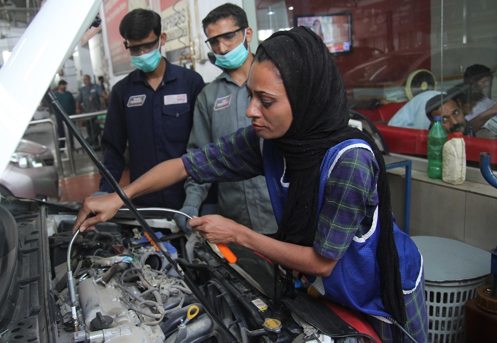 In this picture taken on September 1, 2018, Pakistani motor mechanic Uzma Nawaz, 24, fixes a car at an auto workshop in Multan. u00e2u20acu201d AFP pic 