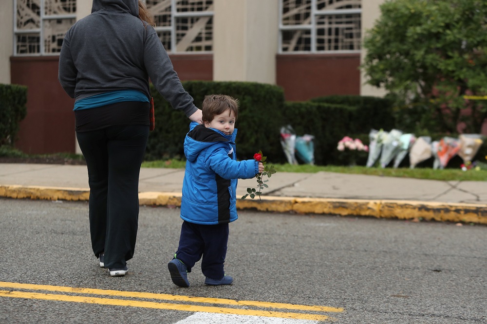 A child carries a flower as he visits an impromptu memorial at the Tree of Life synagogue following Saturday's shooting at the synagogue in Pittsburgh, Pennsylvania, October 28, 2018. u00e2u20acu201d Reuters pic
