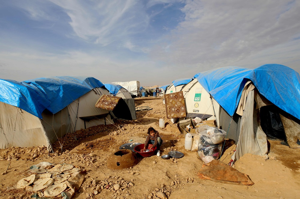 A displaced Syrian girl, who was forced to leave her hometown by the war against the Islamic State group, washes dishes at the Ain Issa camp December 18, 2017. u00e2u20acu201d AFP pic  