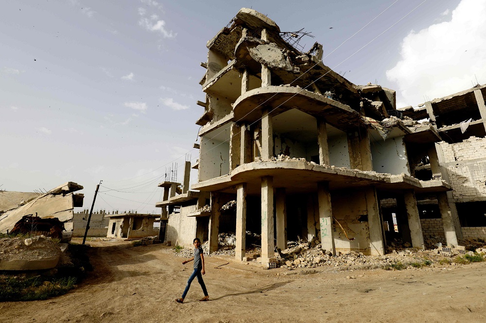 A Syriann walks past destroyed buildings in Kobane May 27, 2018. u00e2u20acu201d AFP pic