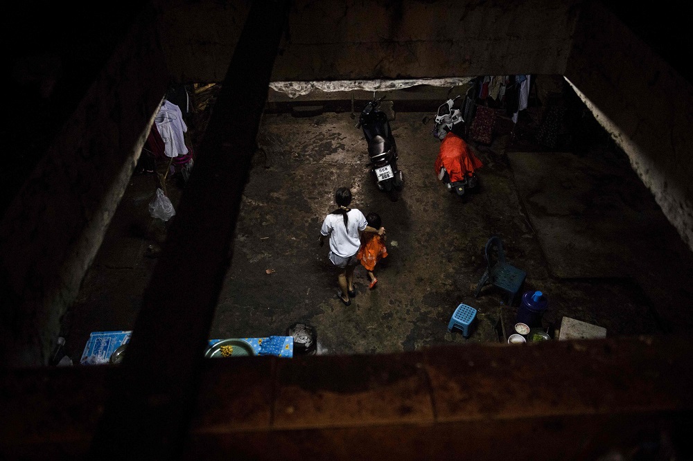 This photo taken on September 20, 2018, shows a Myanmar migrant worker walking with her child at a housing complex behind a seafood market in the Thai coastal province of Samut Sakhon. u00e2u20acu201d AFP pic   