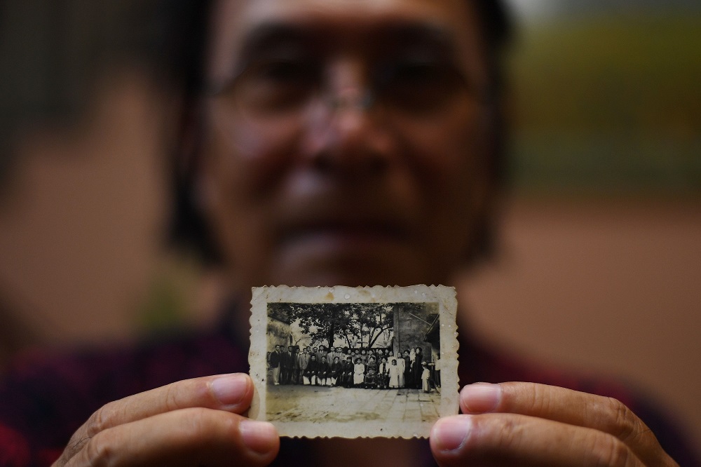 This picture taken on September 25, 2018, shows Cao Van Dzan posing with the only photograph of his First World War (WWI) veteran grandfather Dang Van Con at his house in Hanoi. u00e2u20acu201d AFP pic 