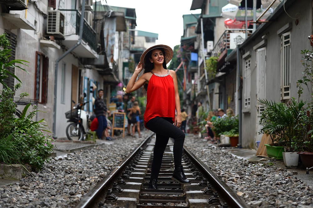 This photo taken on October 20, 2018, shows a tourist posing for a photo on a railway track passing through an old residential district in central Hanoi. u00e2u20acu201d AFP pic 