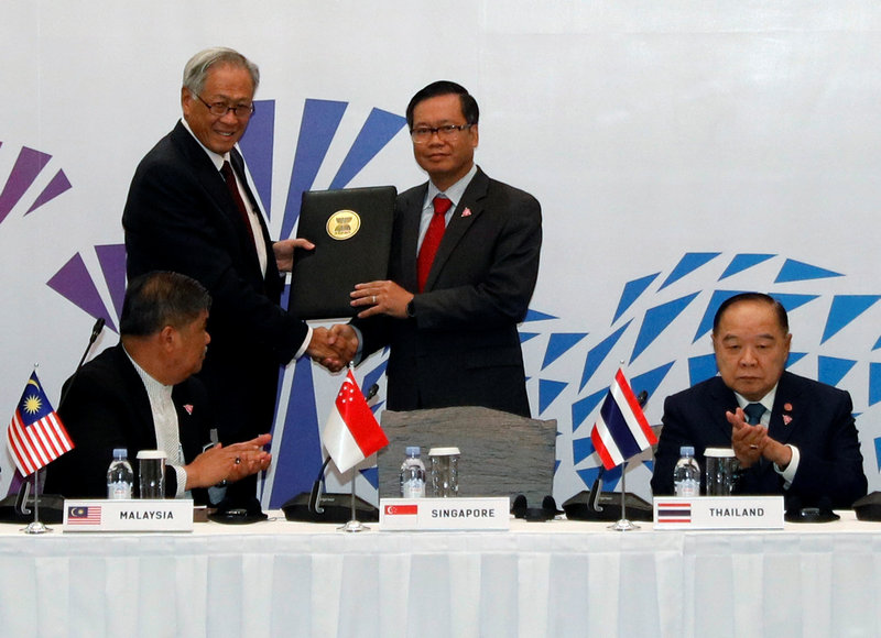 Singapore's Defence Minister Ng Eng Hen (left) presents a signed joint declaration to Asean Deputy Secretary General Hoang Anh Tuan at the Asean Defence Ministers' Meeting in Singapore October 19, 2018. u00e2u20acu201d Reuters picn
