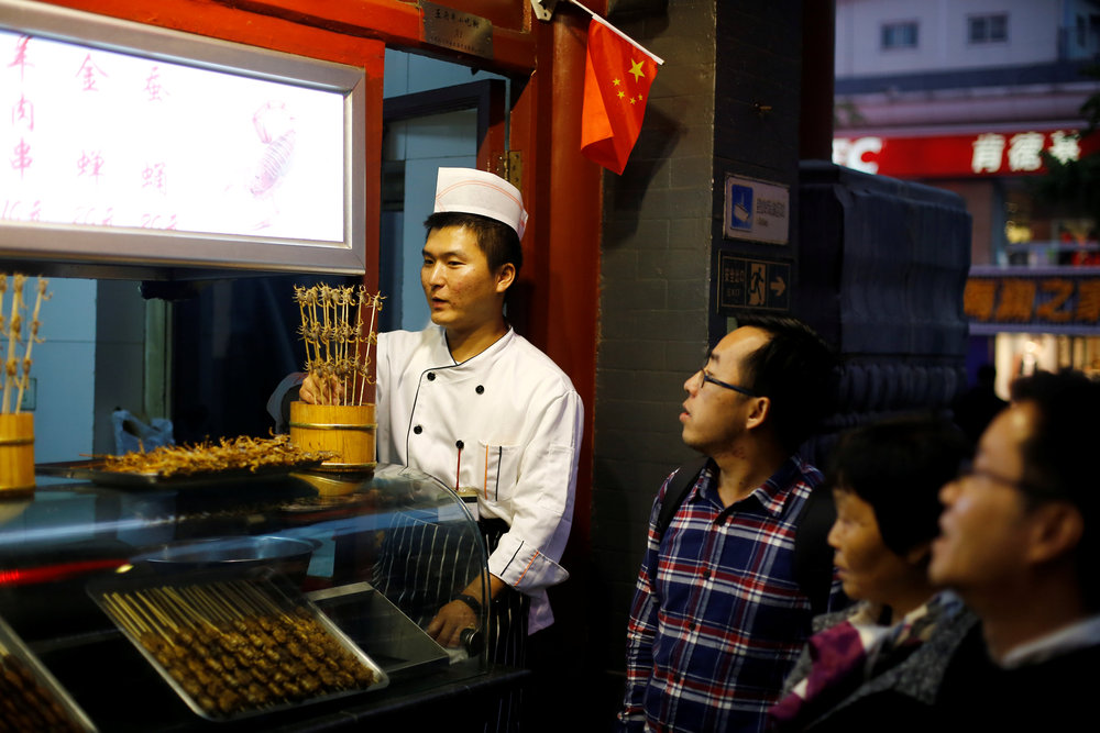 People look at live scorpions at a food stall in Wangfujing Street, a pedestrianised shopping area, in Beijing, China October 15, 2018. u00e2u20acu201d Reuters pic