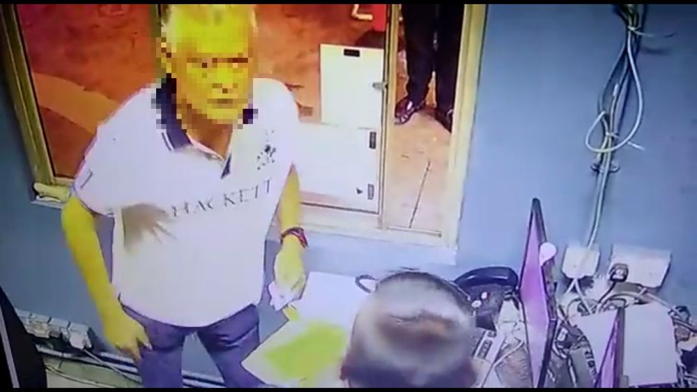 A screenshot of a Facebook video showing a u00e2u20acu02dcDatuku00e2u20acu2122 assaulting a parking attendant at a hotel in Kuala Lumpur. 