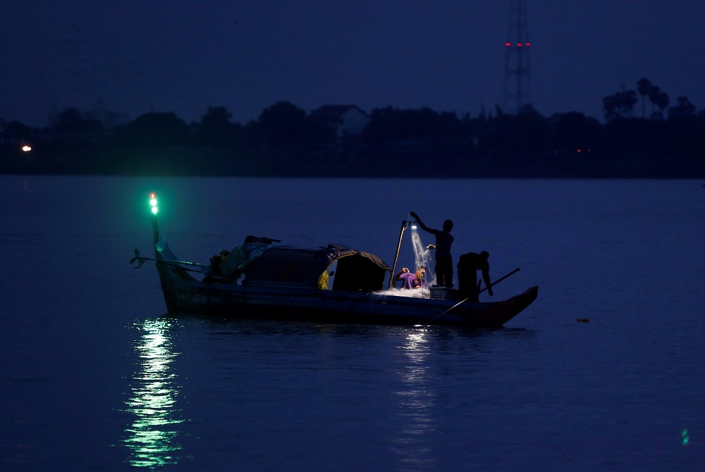Fishermen collect fish from a fishing net on their boat on Tonle Chaktomuk River in Phnom Penh, Cambodia May 22, 2018. u00e2u20acu201d Reuters pic 