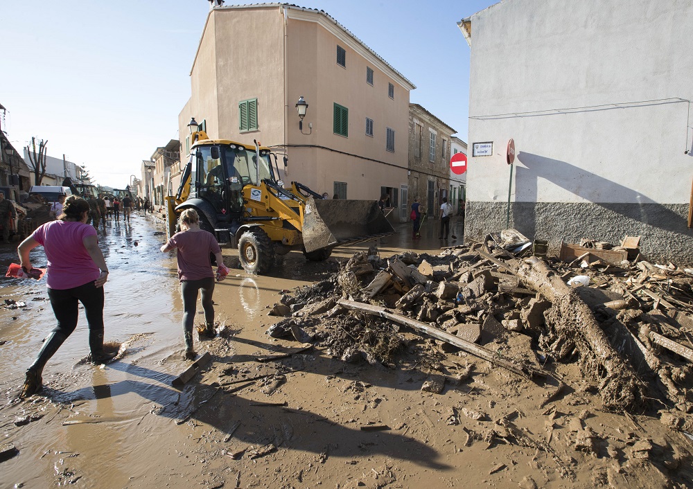 People remove mud from a street in Sant Llorenc des Cardassar on the Spanish Balearic island of Majorca on October 11, 2018. u00e2u20acu201d AFP pic