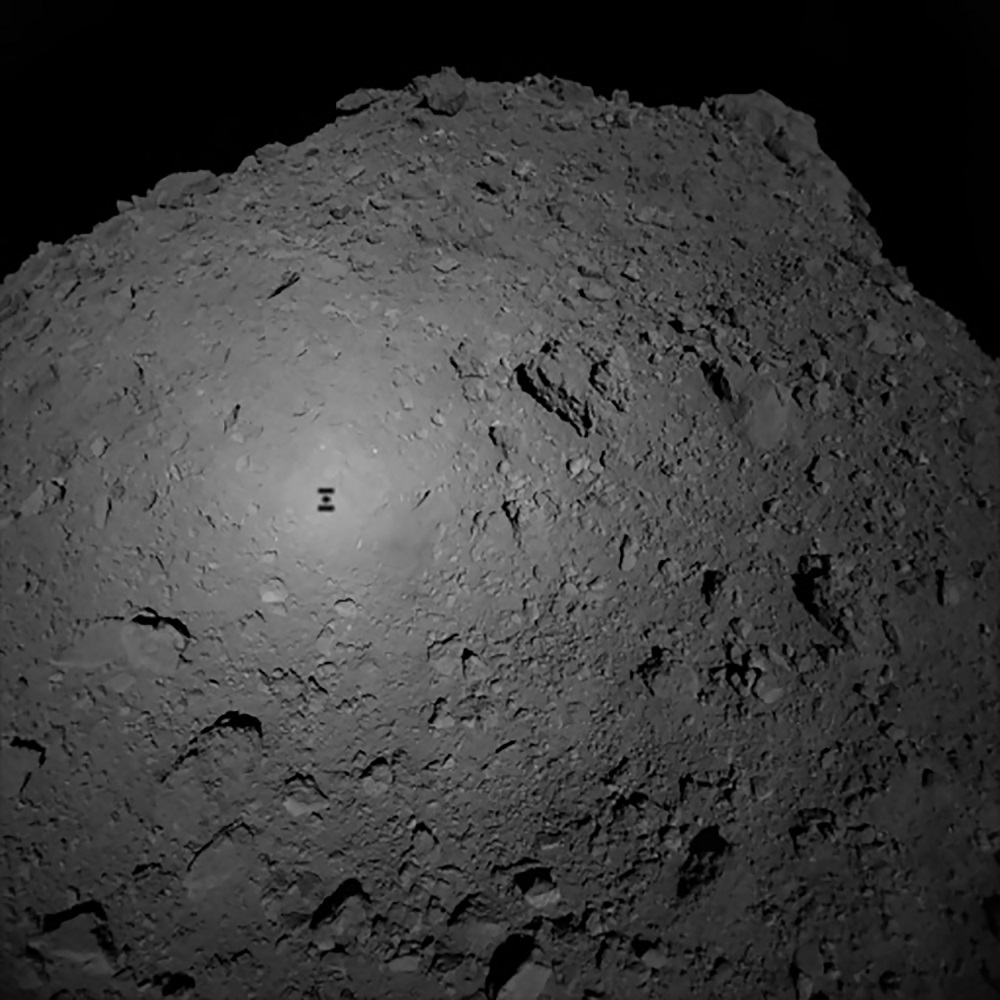 This handout photograph received from Hayabusa2 spacecraft and made available by the Japan Aerospace Exploration Agency shows the shadow of Japanese spacecraft Hayabusa2 (left) over the asteroid Ryugu October 3, 2018. u00e2u20acu201d AFP pic