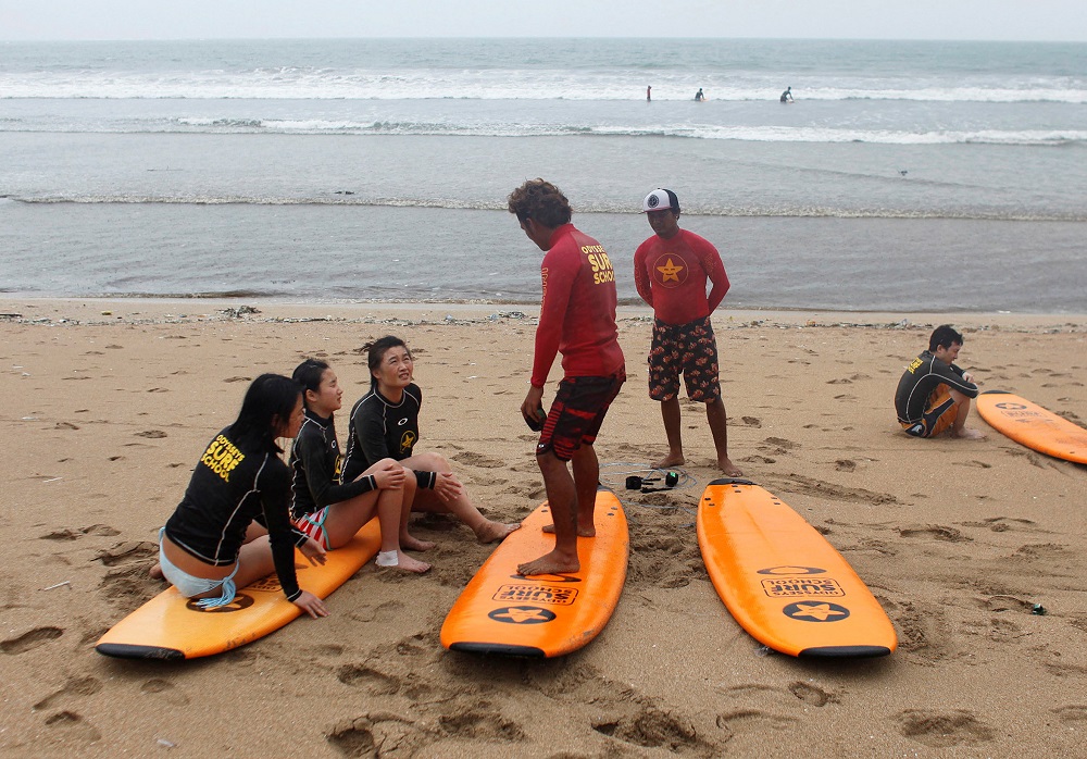 Tourists sit as they take surf course during the Christmas and New Year holiday in Kuta beach, Bali, Indonesia December 25, 2017. u00e2u20acu201d Reuters pic  