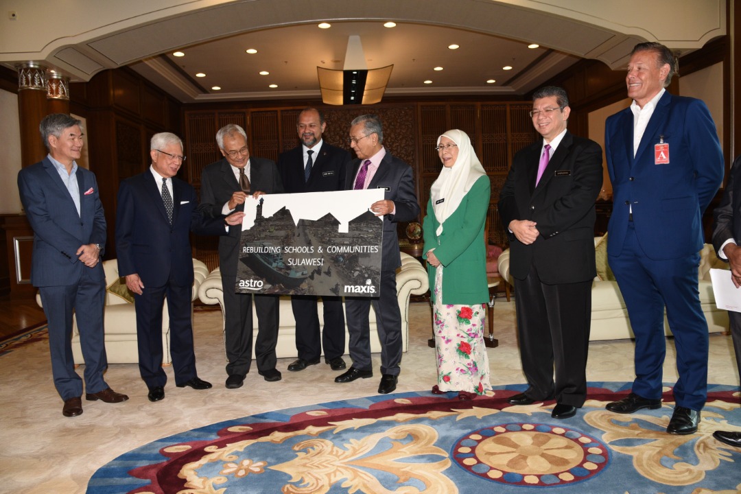 Astro chairman Tun Zaki Azmi (third from left) and Maxis chairman Raja Tan Sri Arshad Raja Tun Uda (second from left) present a mock cheque to Prime Minister Tun Dr Mahathir Mohamad at his office in Perdana Putra. — Picture courtesy of Astro 