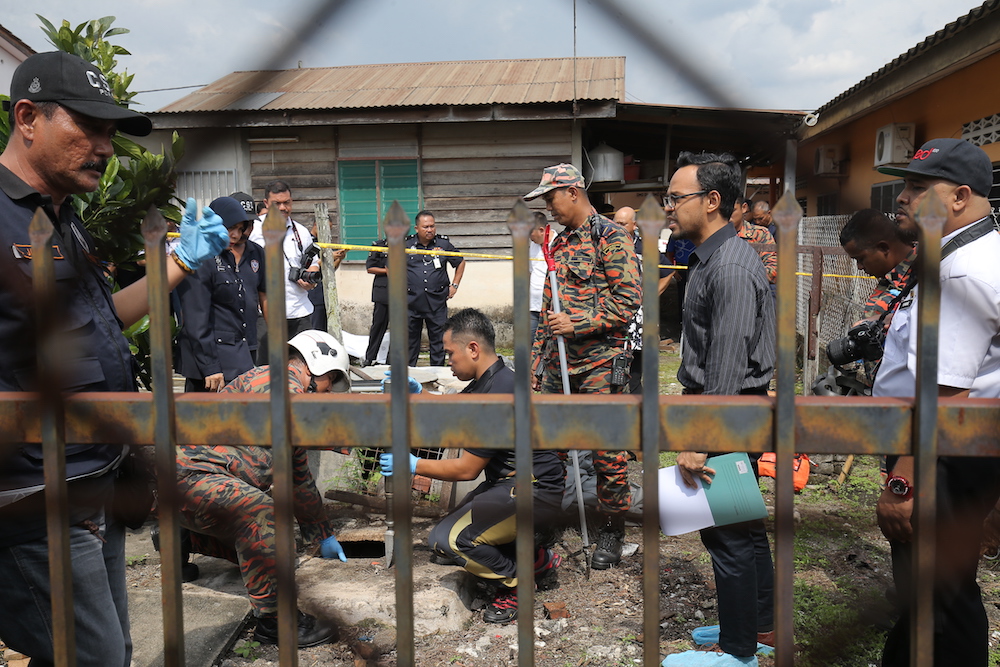 Fire and Rescue Department personnel investigate the murder of a senior citizen at Kampung Baru Khantan in Chemor. u00e2u20acu201d Picture by Marcus Pheong
