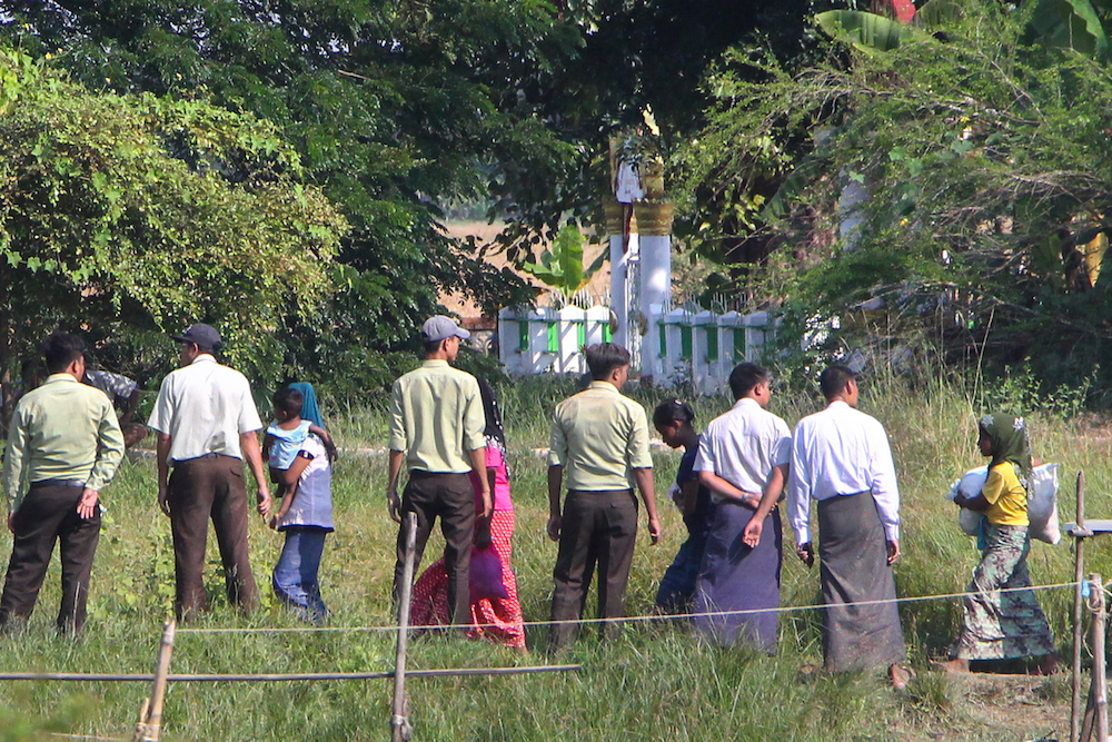 Myanmar authorities look at a group of Rohingya Muslim women walking on a field in Kyauktan township south of Yangon November 16, 2018, after their boat washed ashore. u00e2u20acu201d AFP pic