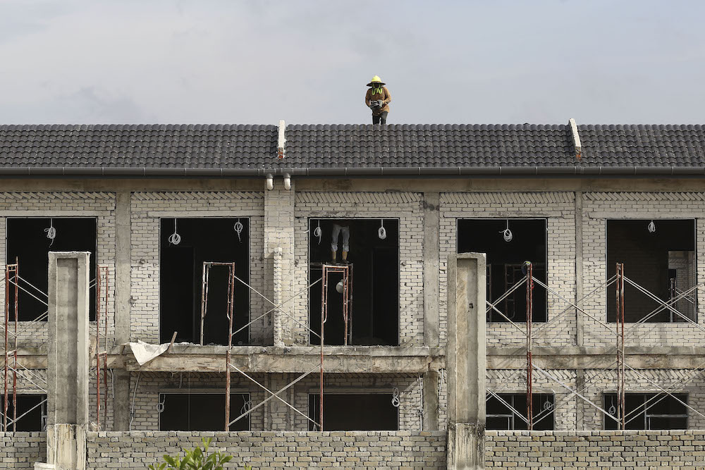 Construction workers lay roof tiles in a residential development in Puncak Alam, Selangor November 1, 2018. u00e2u20acu201d Picture by Yusof Mat Isa