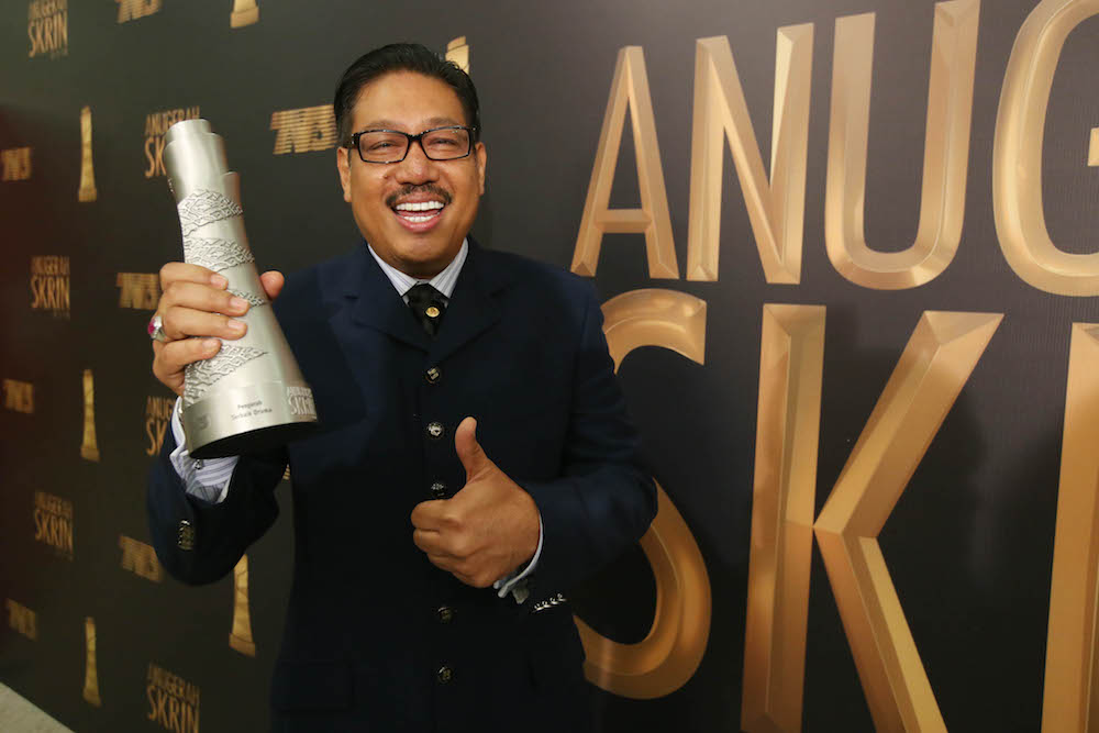 Rashid Sibir with his Best Drama Director trophy. — Picture by Azinuddin Ghazali