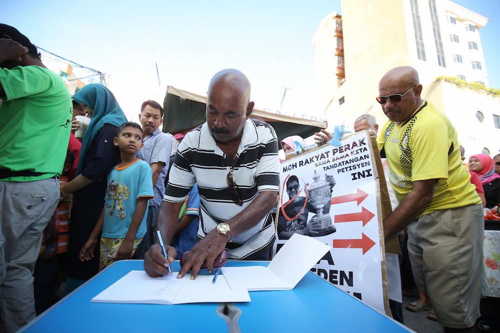 Perak football supporters join a signature campaign seeking the resignation of Perak Football Association president Hasnul Zulkarnain Abd Munaim. — Picture by Marcus Pheong