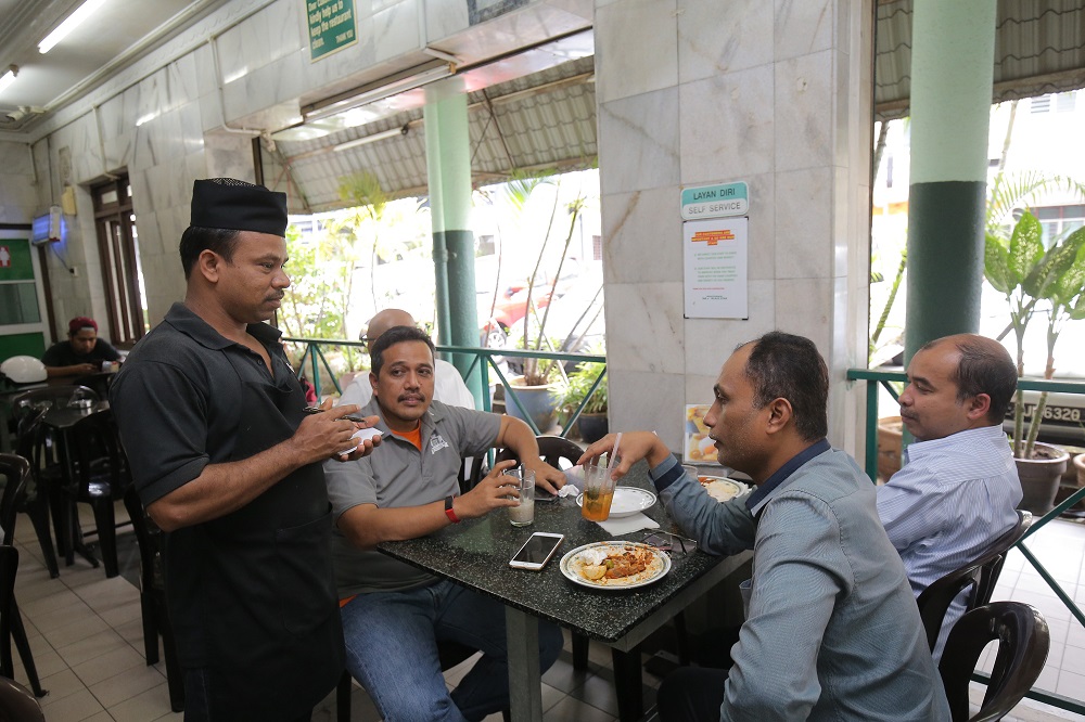 A waiter takes the order for a table at Restoran M. Salim in Ipoh November 14, 2018. 