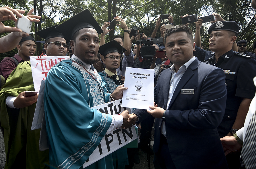 Activist Muhammad Faizzuddin Mohd Zai (left), hands over the memorandum to Education Minister Maszlee Malik’s representative, Abdul Hannaan Khairy, in Kuala Lumpur November 13, 2018.