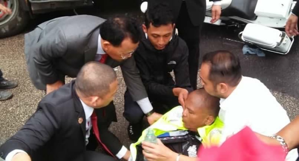Johor Mentri Besar Datuk Osman Sapian (left) and his aides calm the injured police outrider who was involved in a minor road accident. — Picture courtesy of Datuk Osman Sapian Facebook page
