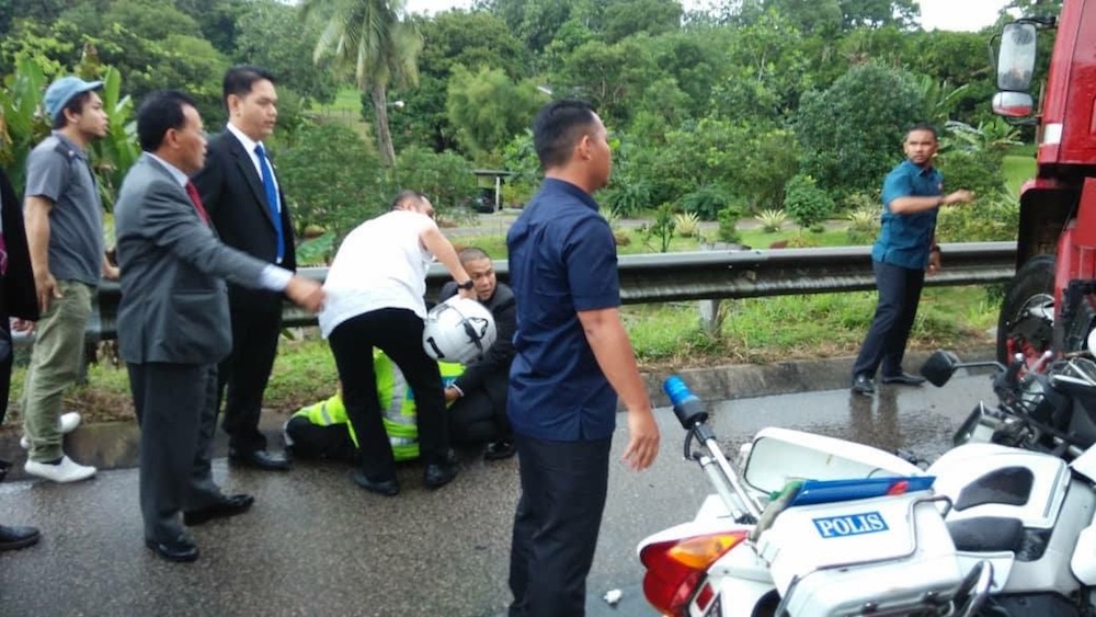 Johor Mentri Besar Datuk Osman Sapian (gesturing from left) assists his police outrider who was involved in a minor road accident. u00e2u20acu201d Picture courtesy of Datuk Osman Sapian Facebook page