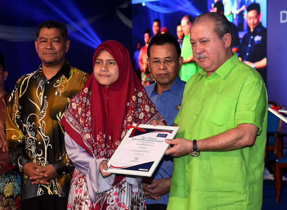 Sultan Ibrahim Sultan Iskandar presents an offer letter for Rumah Impian Bangsa Johor to Farah Nabiha Mohd Fuad in Johor Baru November 21, 2018. u00e2u20acu201d Bernama pic