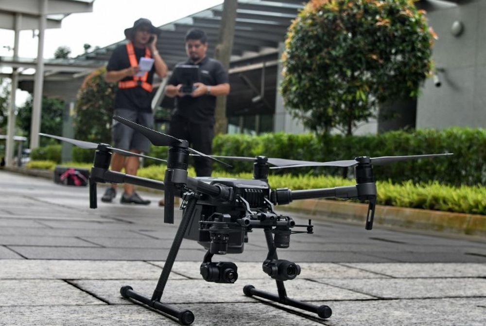 Staff members of Singapore technology firm H3 Dynamics preparing to fly a drone to inspect a building facade in Singapore, on September 9, 2018. u00e2u20acu201d AFP pic