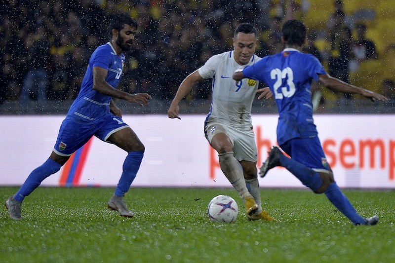 Malaysian footballer Norshahrul Idlan Talaha (centre) tries to move the ball past the Maldivesu00e2u20acu2122 defence at the Malaysia-Maldives final warm up match at the Bukit Jalil Stadium in Shah Alam, November 3, 2018n
