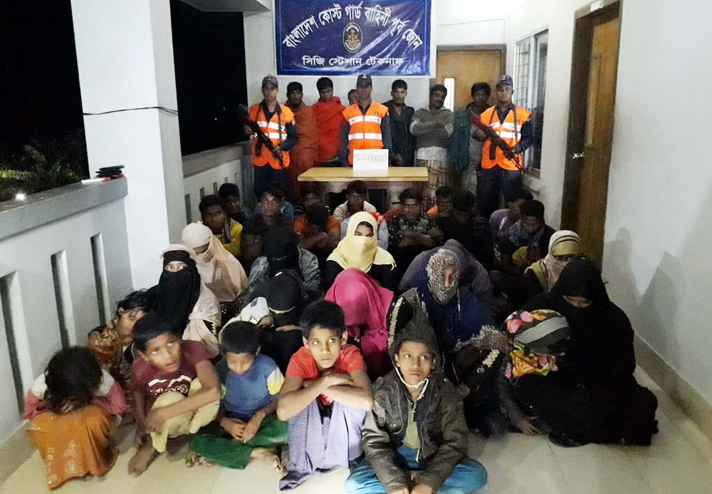 A handout released on November 7, 2018 by the Bangladesh Coast Guard shows Coast Guard members with Rohingya refugees and alleged traffickers in Teknaf coast guard station in Bangladesh. u00e2u20acu201d AFP pic