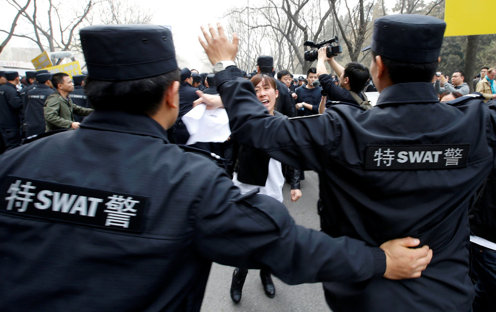 A family member of a passenger onboard Malaysia Airlines Flight MH370 shouts as policemen attempt to prevent protestors denouncing the Malaysian government and the airline in Beijing March 25, 2014. u00e2u20acu201d Reuters pic